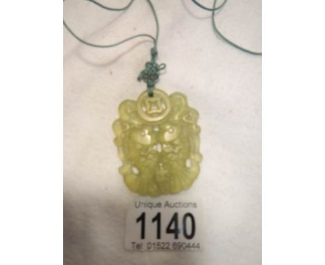 A light green jade pendant bound with a cord feng shui mystic knot
