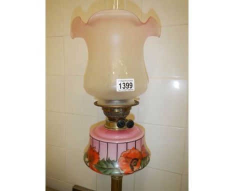 A Victorian brass column oil lamp with art nouveau decorated cranberry font and later shade