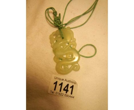 A light green jade necklace on feng shui mystic knot