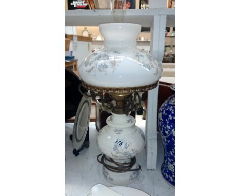 A pottery oil lamp with blue floral decoration converted to electric