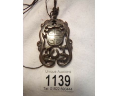 A brown jade pendant bound with a cord feng shui mystic knot