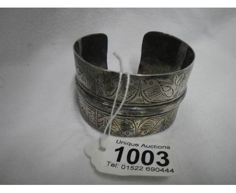 A middle eastern white metal slave calf bangle decorated with fishes and bearing 4 marks