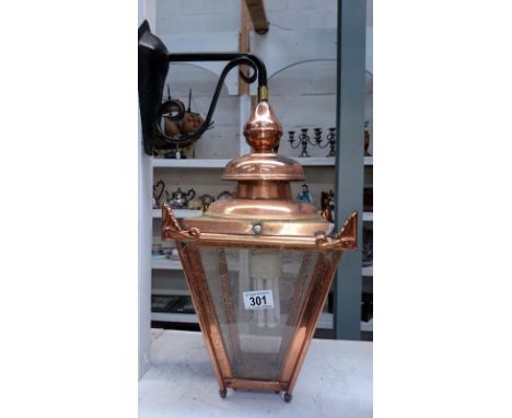 A copper street lamp on wall bracket