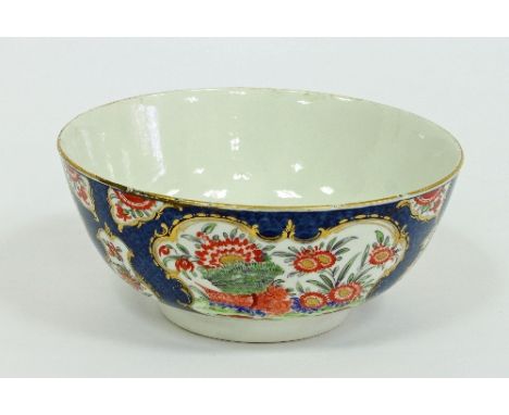 A Worcester slop bowl, circa 1770, painted in the Kakiemon style with cartouches of flowers, foliage and banded hedges edged 