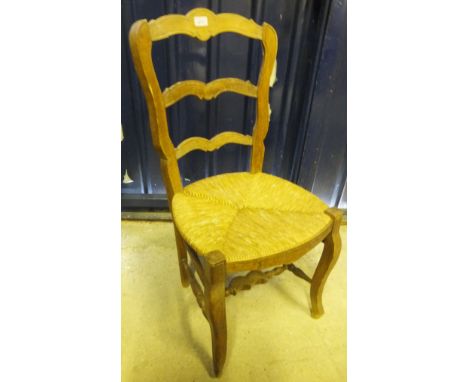 A set of six French beech framed rush seated ladder back dining chairs