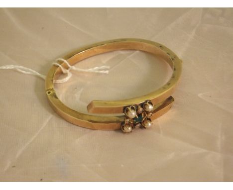 A hollow gold, seed pearl and emerald mounted bangle CONDITION REPORTS Weight approx 10.8g including pearls/stone. Wear and s