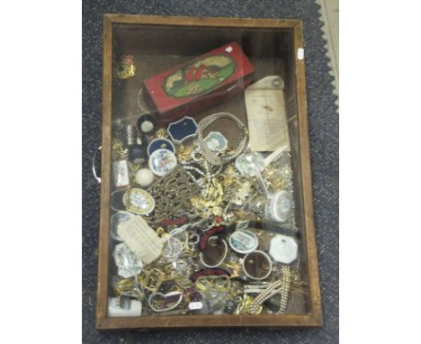 A display case containing various costume jewellery to include brooches, necklaces, etc, a tin containing assorted dominoes, 