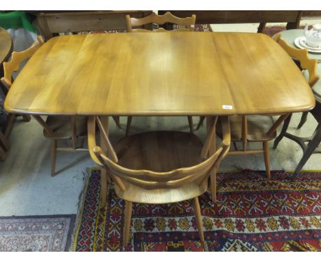A light elm Ercol drop-leaf dining table with four chairs