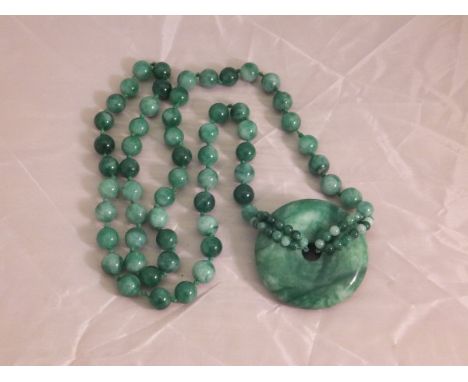 A jade beaded necklace with ring pendant