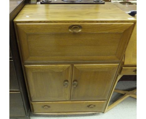 An Ercol light elm cabinet with fall front compartment above two doors and single drawer