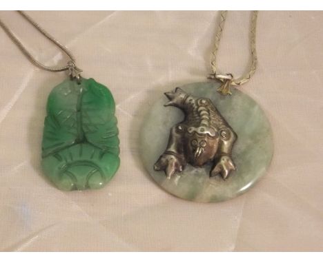 A jade pendant carved as two fish on a silver chain, together with a jade pendant set with white serpent like creature, house