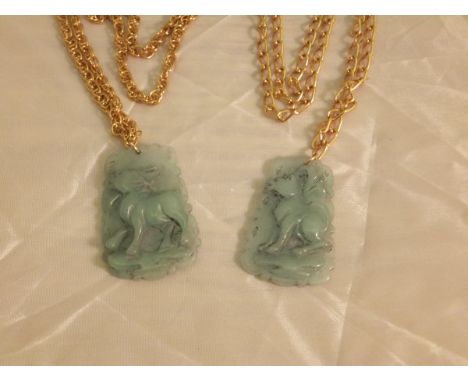 Two carved jade pendants, each depicting a hooved animal