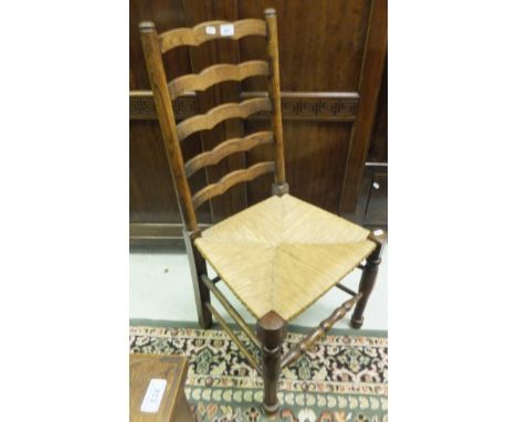 A set of five early 20th Century oak rush seat ladder back dining chairs