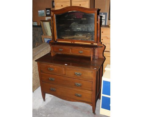 An Edwardian mahogany dressing chest, with bevelled arched mirror over an arrangement of drawers. Width 107 cm. CONDITION REP