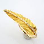 An exquisite 14k yellow gold feather ring detailed with brilliant diamonds.