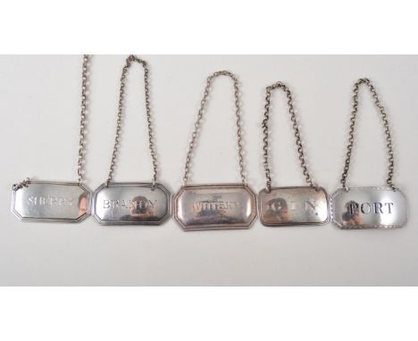 Five hallmarked silver wine labels, Whisky, Gin, Port, Brandy and Sherry and a pair of silver plated fish servers.