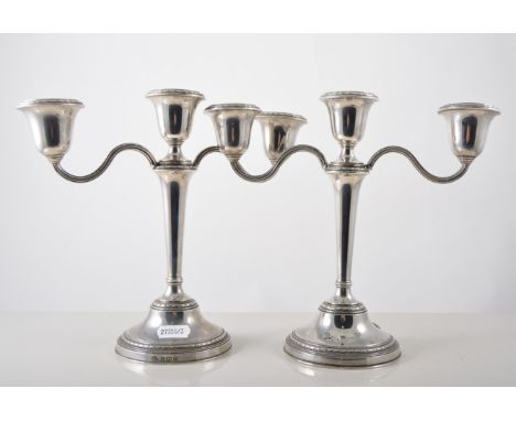 Pair of silver three light candelabra with detachable sconces and centre finial, filled bases, Birmingham, 21cm.