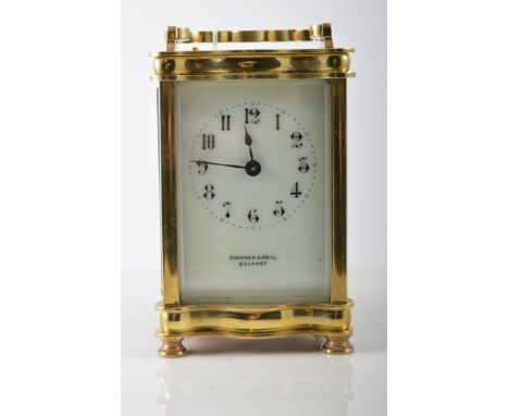 Brass time piece carriage clock, with white enamel dial with Arabic numeral chapter ring named Sharman D Neill, Belfast, serp