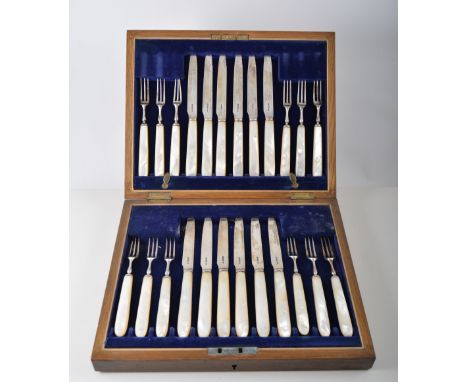 Fitted oak canteen containing twelve silver dessert knives and forks with mother of pearl handles, the knives having a serrat