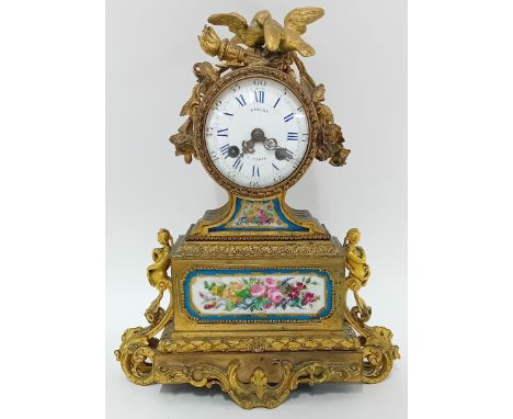A gilt mantle clock, with Roman and Arabic minutes enamel dial and porcelain Louis Sevres style floral decoration to panel be