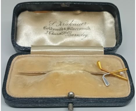 A decorative, yellow and white metal tie pin in the form of golf clubs and a pearl ball, in a fitted case. Property of J.H. G