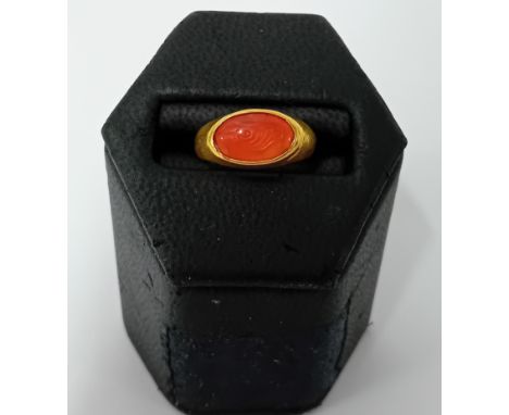 A Roman gold ring, formed from a round hoop with a D section and a bezel that secures a carnelian intaglio. The intaglio depi