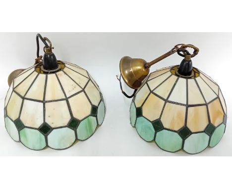 A pair of Tiffany-style green and yellow stained glass light shades, with ceiling fittings.