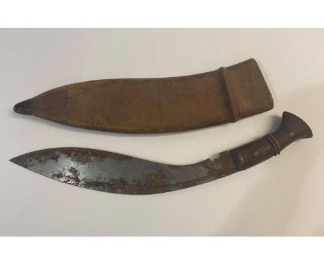 A Kukri of traditional design, the 34cm blade stamped 1915, with wooden handle, in a leather scabbard stamped with a Governme