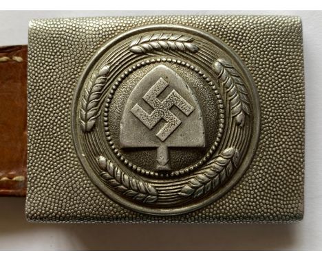 A Second World War German Labour Corps Belt Buckle, early aluminium type with  'Pebbled' finish and probably original brown l