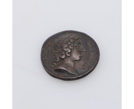 A small silver coronation medal, 'Carlos Rex' with raised relief bust with laureals, reverse with a kneeling figure receiving