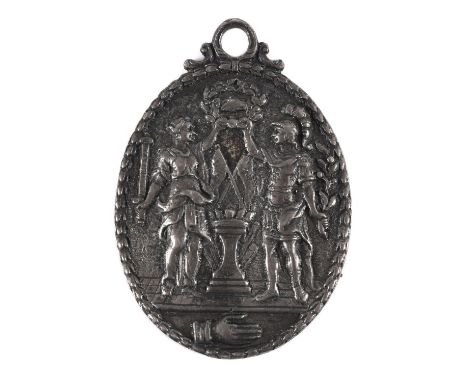 An unusual unmarked silver badge with a male and female figure standing either side of an altar, holding a wreath aloft with 