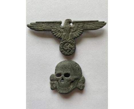 A German SS Cap Insignia Set in zinc comprising eagle with wings outstretched and second type skull, with brass fixing pins t