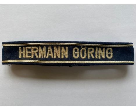 A Second World War German Luftwaffe 'Hermann Goring' cuffband, grey cotton machine embroidered on a dark blue felt with a whi