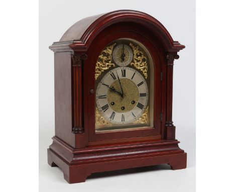 A mahogany dome topped bracket clock by Gustav Becker. With carved column supports and having gilt brass arch topped dial wit