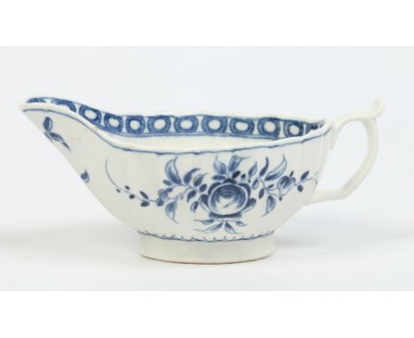 A small fluted Worcester sauceboat. Painted in underglaze blue with the formal rose pattern and with a cell border. Crescent 