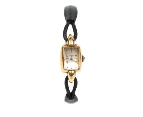 A ladies 18 carat gold Omega manual wristwatch on leather strap. With teardrop lugs, and rectangular silvered dial with dot a