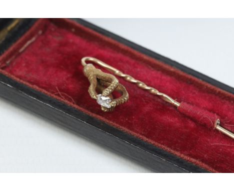 A cased yellow metal stick pin. The terminal formed as an eagles talon is clutching an oval cut diamond.  Condition Report. T