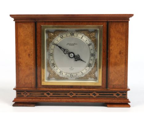 An Art Deco walnut cased eight day mantel clock, signed Elliot. With silvered dial and blind fret carving, 20.5cm wide. Condi