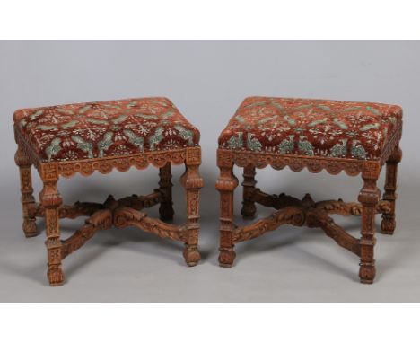 A pair of Chippendale style carved mahogany stools with tapering overstuffed seats. Raised on square supports and with x fram