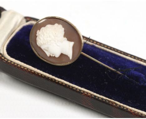 A Victorian 9 carat gold stick pin in case. With an ovoid terminal set with a carved hardstone cameo portrait of a young girl