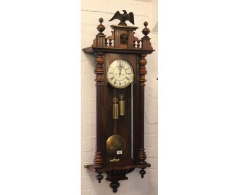 A nineteenth century twin weight Vienna wall clock in carved walnut frame. With enamel dial having Roman numeral markers and 