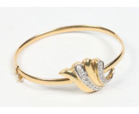An 18 carat gold bangle with scrolling terminal set with cubic zirconias. 13.4 grams, 6.25cm. Condition Report. To be used as