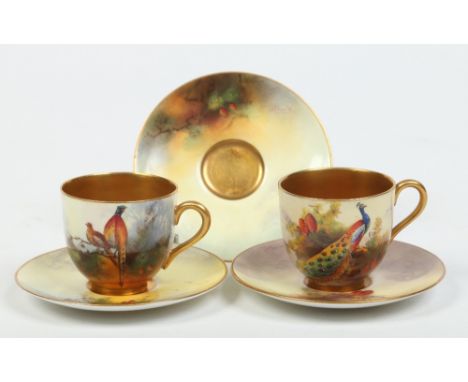 Two Royal Worcester coffee cups and saucers along with another saucer. One cup and saucer painted by Harry Austin with a peac