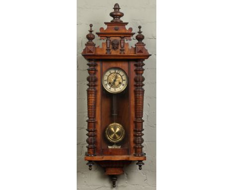 A late nineteenth century Vienna wall clock in walnut case. With gilt dial having enamel chapter ring and housing a twin trai