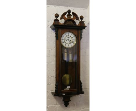 A nineteenth century walnut cased Vienna twin weight wall clock, with enamel dial having Roman numeral markers and subsidiary