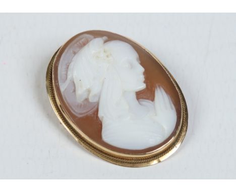 An 18 carat gold oval cameo pendant / brooch. Depicting the portrait of a female angel at prayer. Stamped 750, 2.75cm. Condit