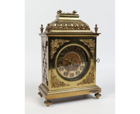 A nineteenth century French brass cased table clock. With ogee caddy top cornered by four urn shaped finials, ornamented with