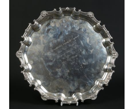 A large heavy gauge silver salver by Garrard & Co. raised on four cast scrolling feet and with dished scalloped border orname