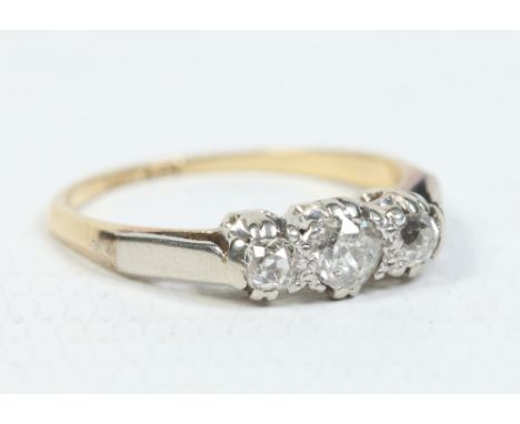 An 18 carat gold and platinum three stone diamond ring. The central brilliant cut stone 0.2ct and the flanking pair 0.1ct. Si