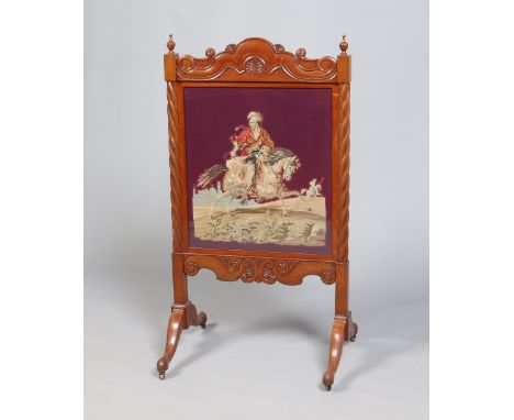A Victorian carved mahogany firescreen with barleytwist supports and with woolwork tapestry depicting a mounted Turkish soldi